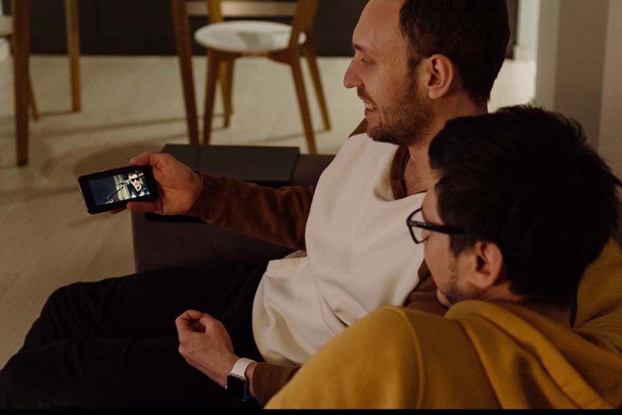 Kaksi ihmistä katsovat videota älypuhelimen ruudulta.